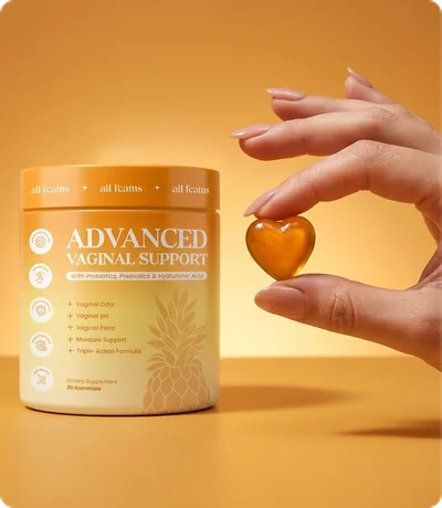 Hand holding one heart-shaped gummy in front of the jar