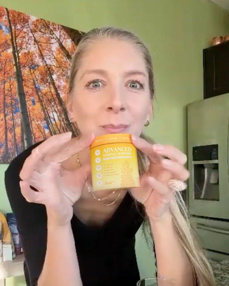 A woman in her kitchen holding the jar